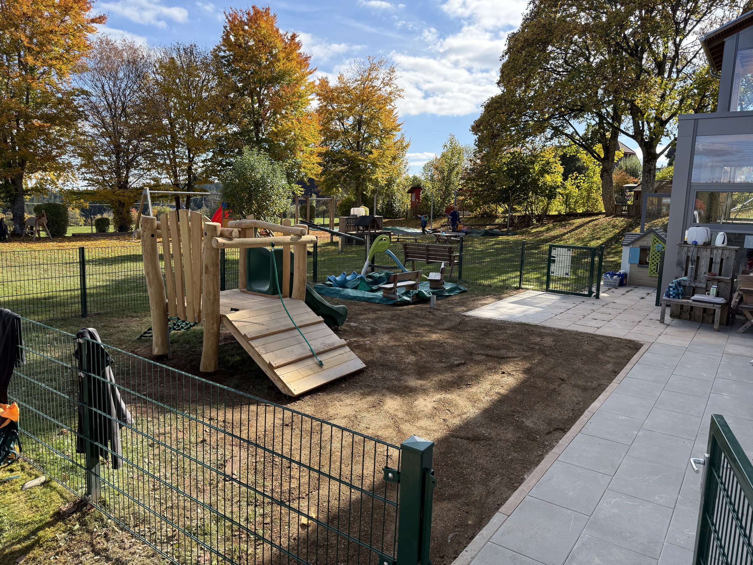 Kinder auf dem neuen Spielplatz mit Rutsche